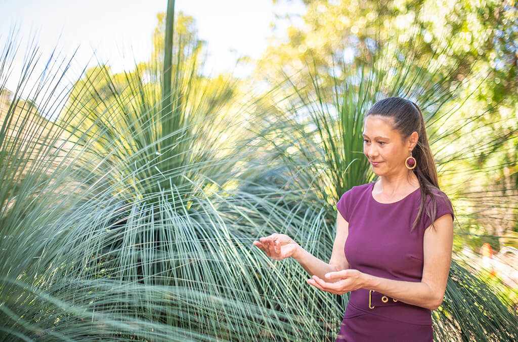 woman touches grass trees