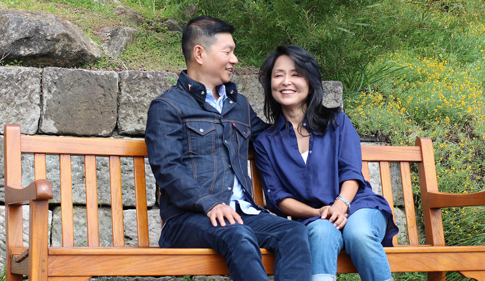 two people sitting on a bench smiling