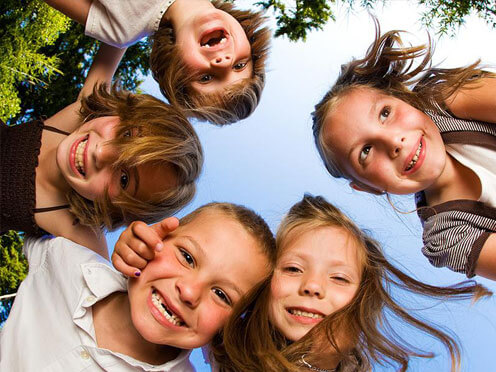 Laughing children in a circle leaning in from above