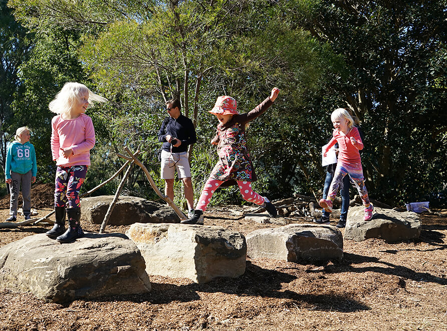 Kids jump on stepping stones in the Garden