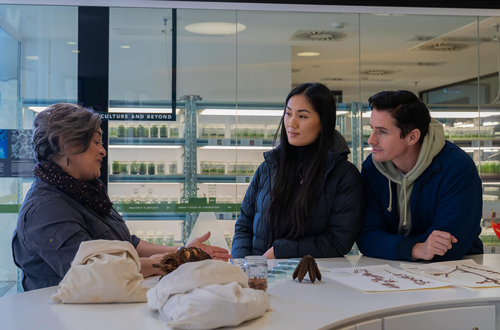 Guide shows seed specimens to two people at the Australian PlantBank