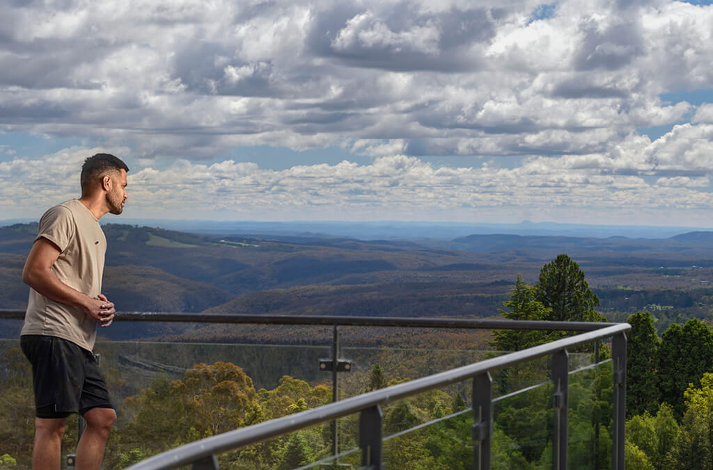 Man on viewing deck gazing at sweeping mountain views at Blue Mountains Botanic Garden