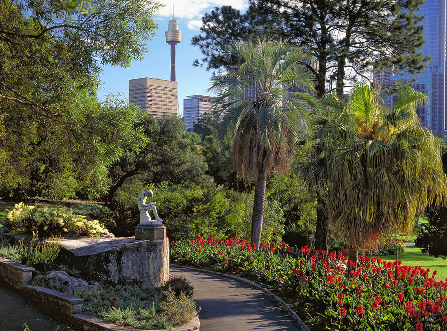statue of a boy overlooking manicured Garden and Sydney CBD in distance