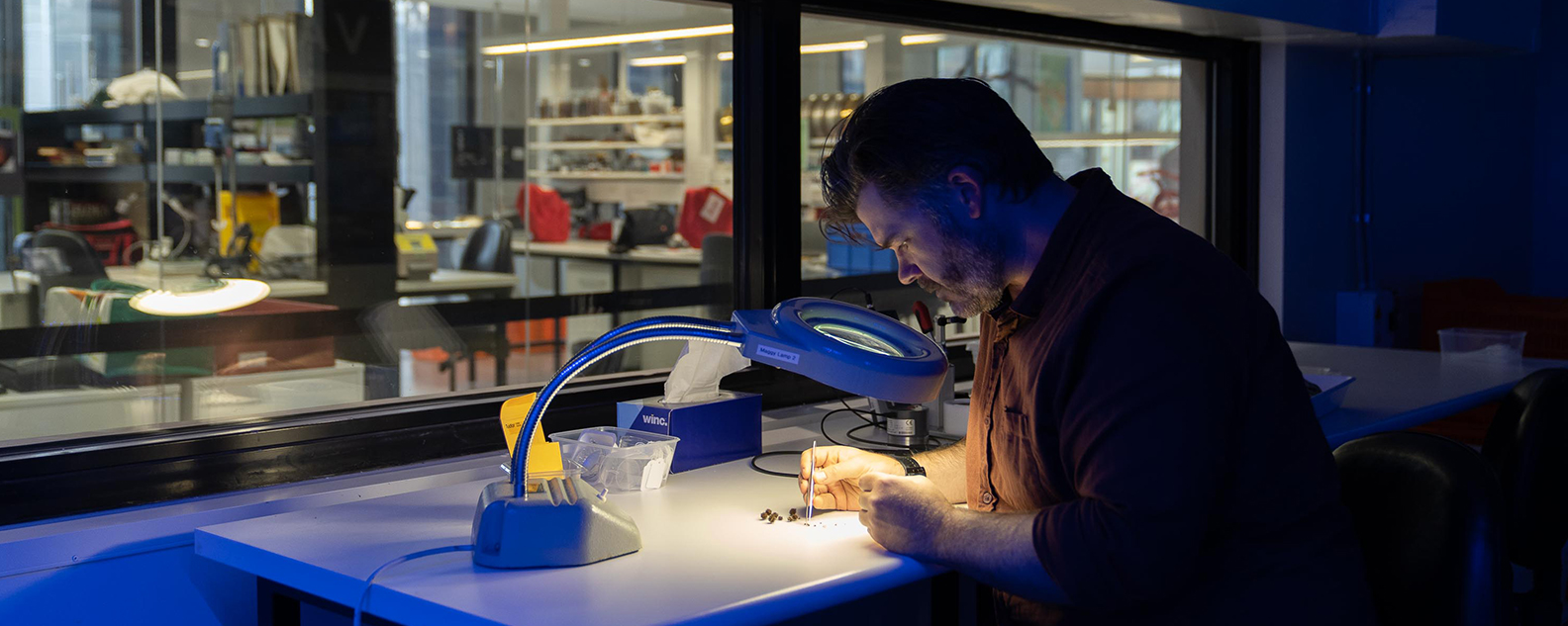 Scientist Nathan Emery examines seeds in a research lab