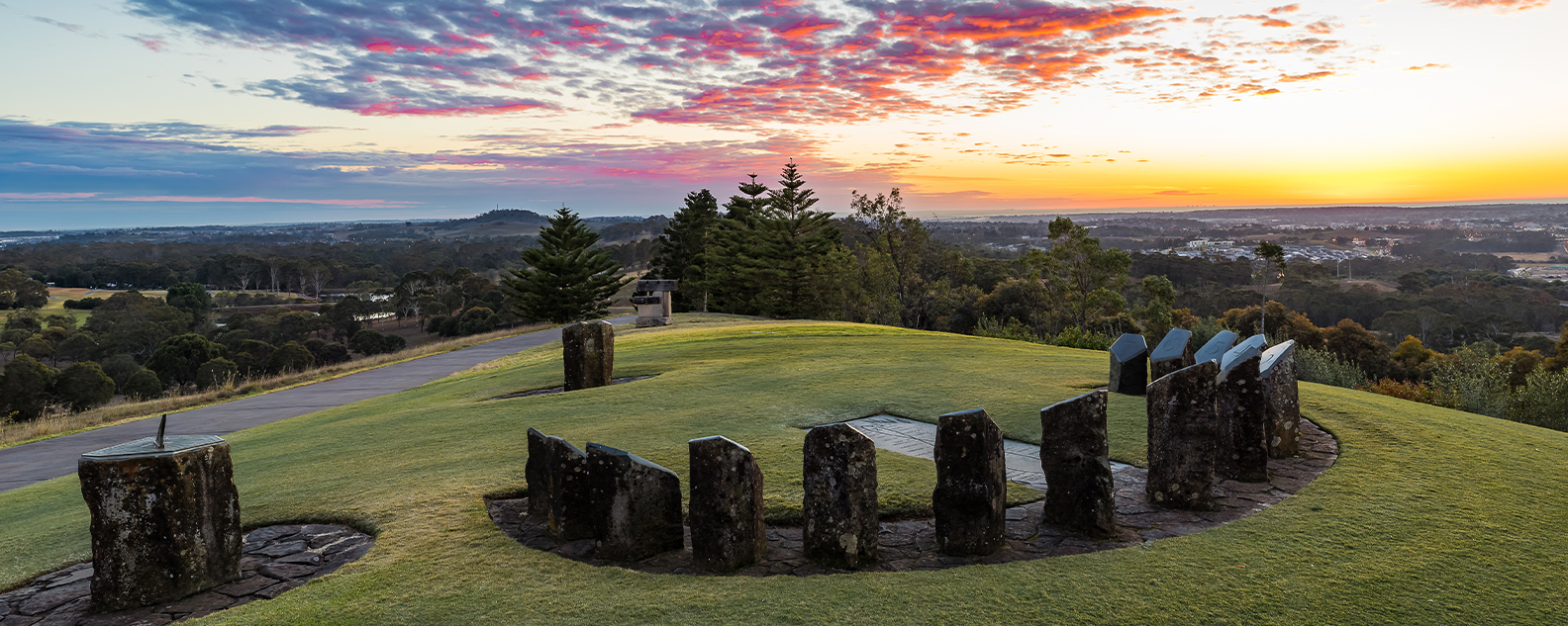 Sundial sculpture on top of hill at sunrise