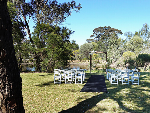 Rows of white chairs set up for an outdoor wedding