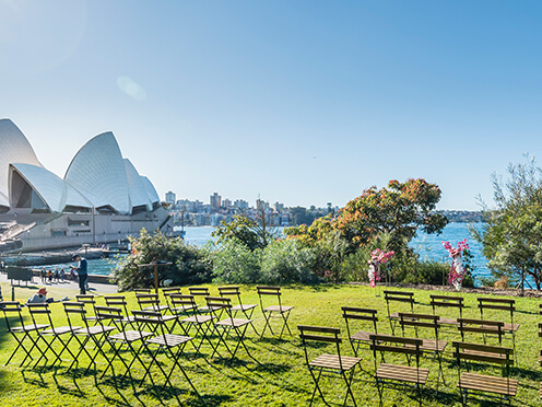 Chairs lined up on lawn, overlooking Sydney Harbour with view of Opera House
