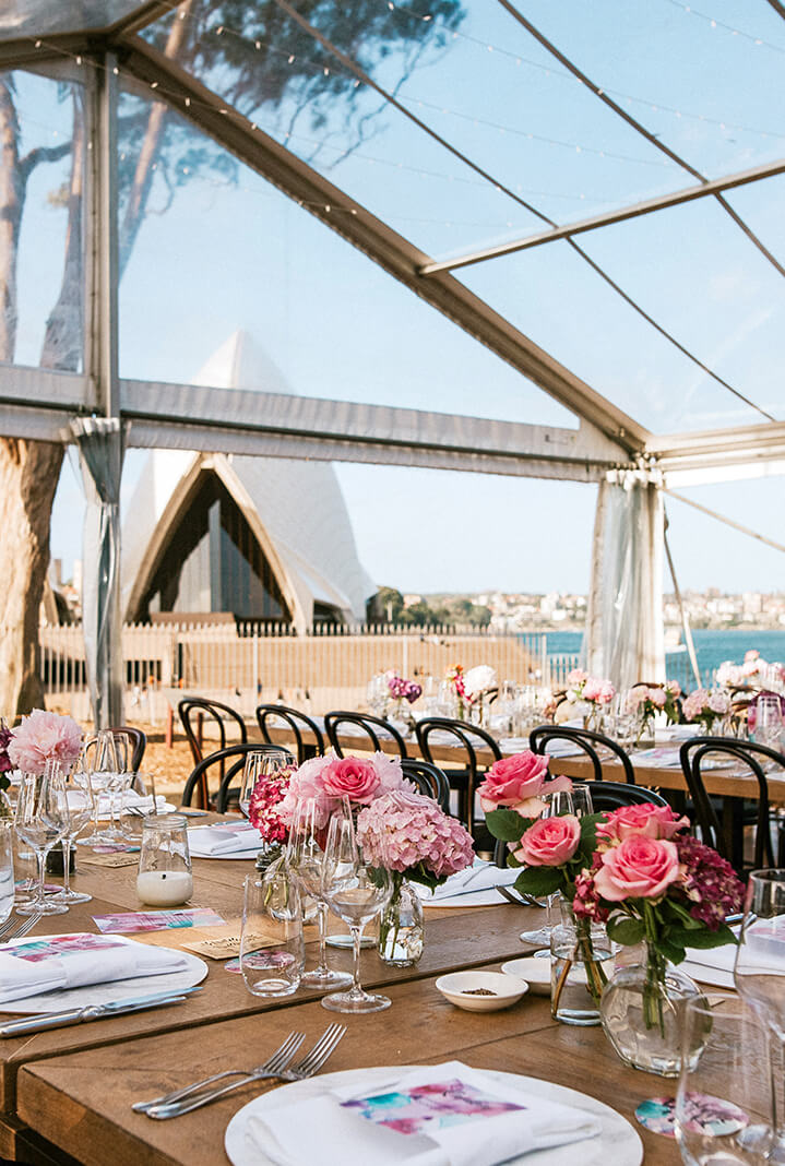 elegant tables with floral arrangements for a wedding reception, looking over Sydney Opera House and Harbour