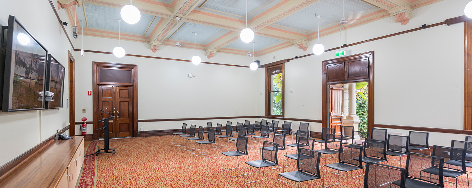 Grand room with heritage floors and carpets, polished wooden trims, presentation screens and chairs