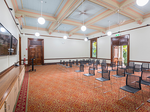 Grand room with heritage floors and carpets, polished wooden trims, presentation screens and chairs