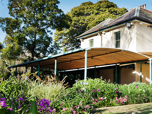 Cream-coloured cottage surrounded by lush formal garden