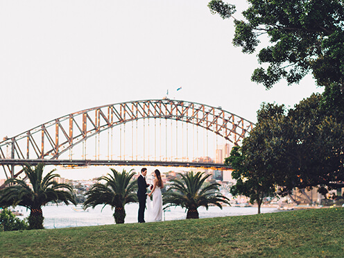 Bride and groom with panoramic Sydney Harbour views behind them