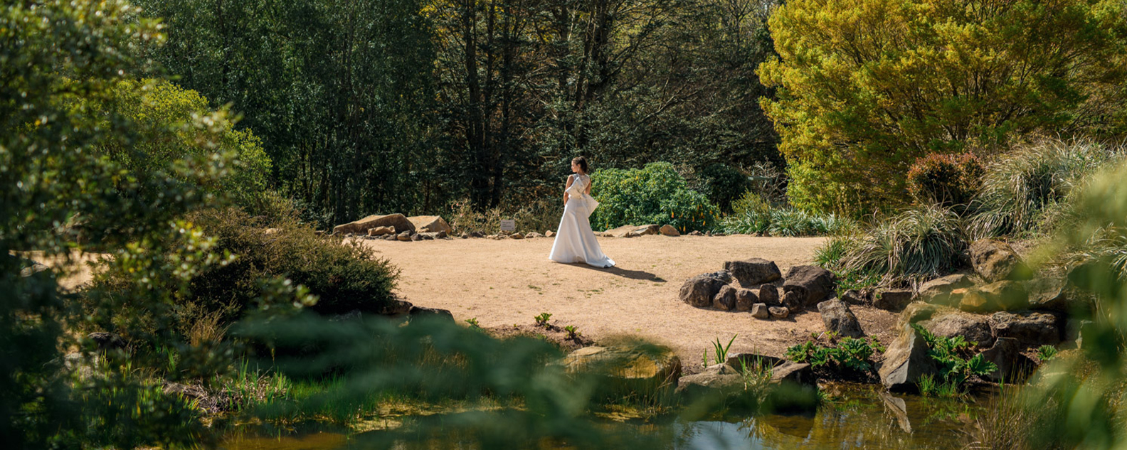 Bride on a sandy clearing next to a pond