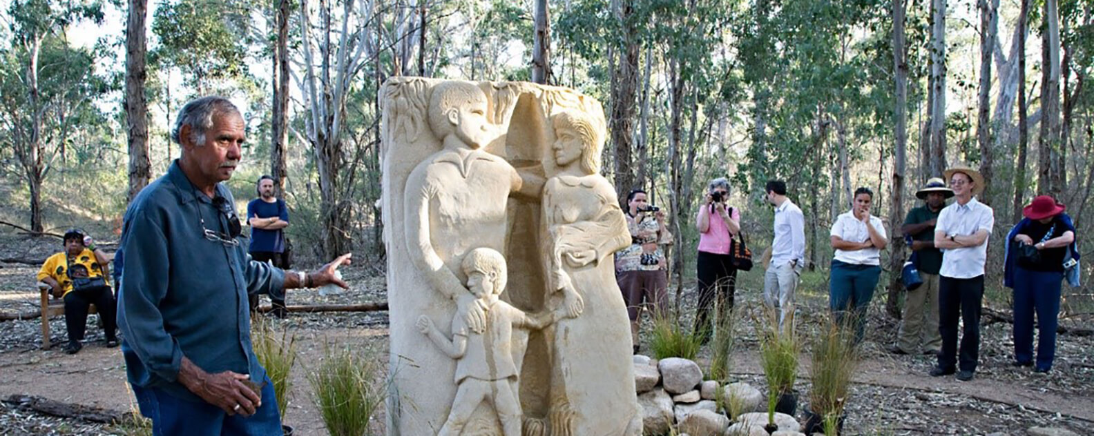 A man stands with a Memorial artwork