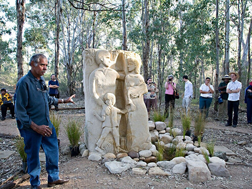 A man stands with a Memorial artwork