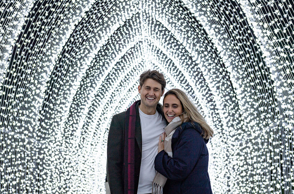 Couple posing under the cathedral installation at Lightscape