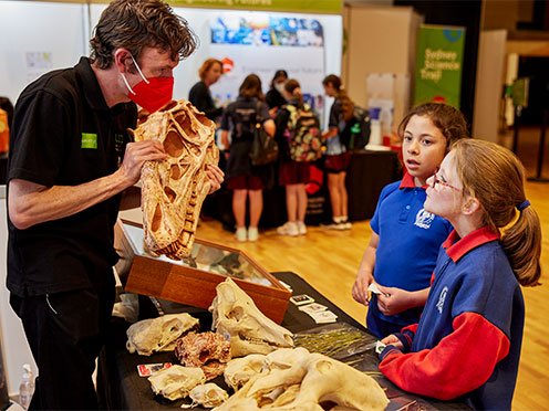 School children being shown dinosaur fossils at the Australian Museum Science Expo
