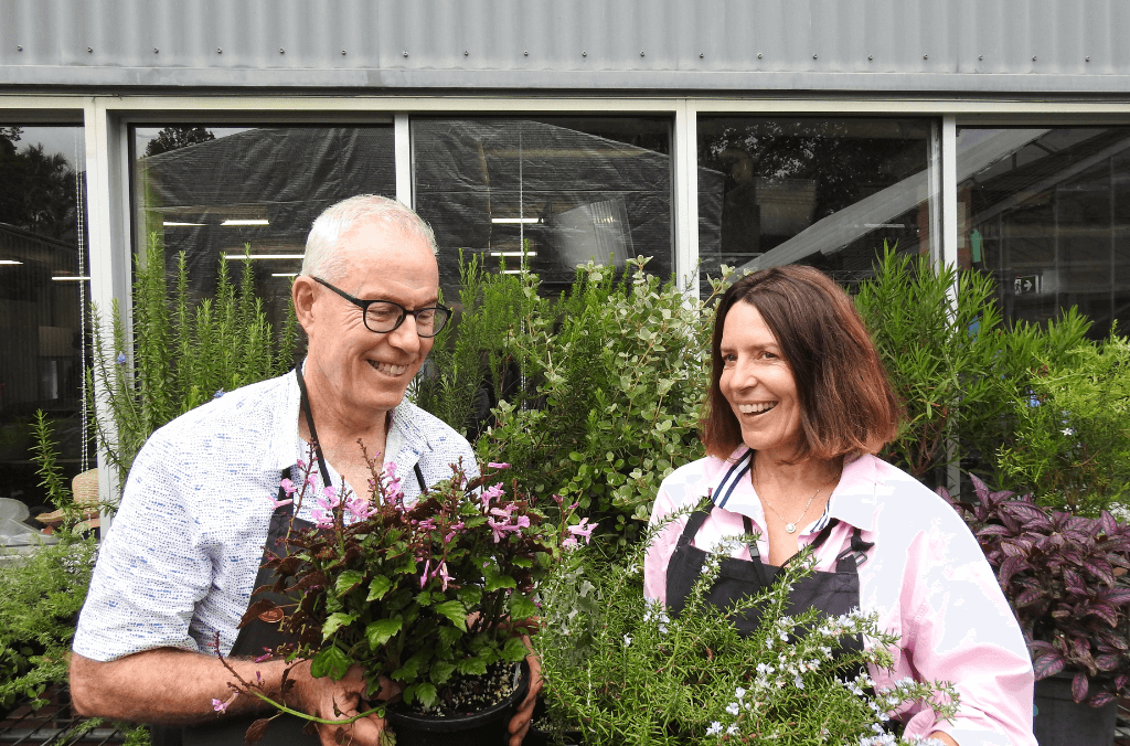 Greg & Liz holding plants and smiling