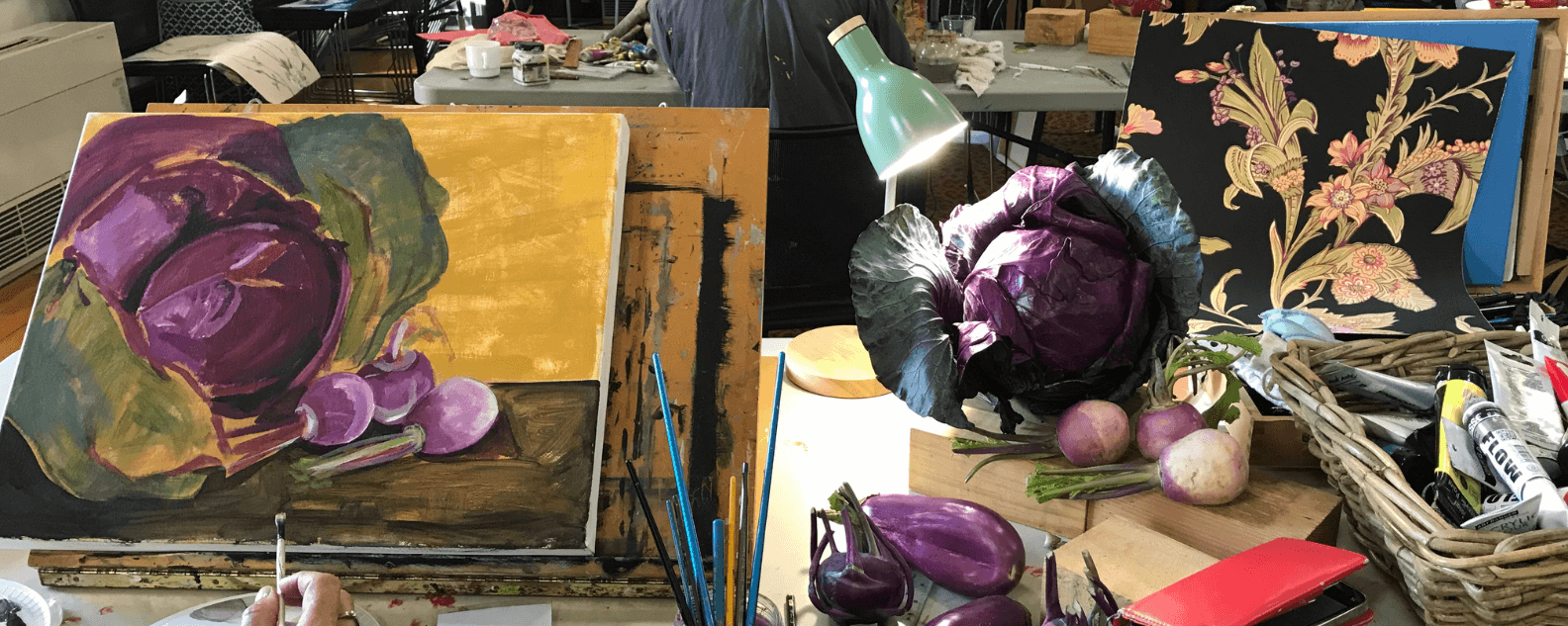 An in progress cabbage being painted in acrylic next to a real cabbage
