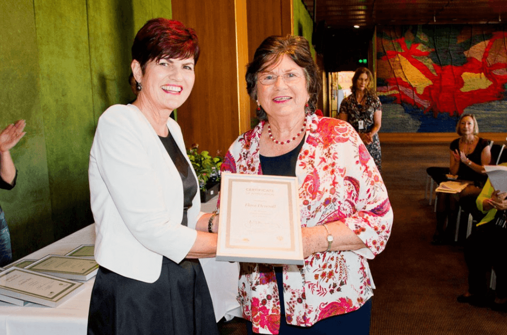 Two woman holding an award
