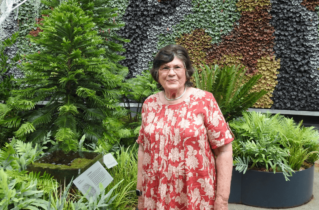 A woman standing in front of a garden bed