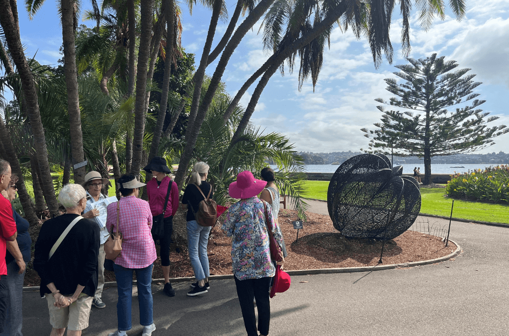 A group on a guided walk looking at the Bronwyn Oliver sculpture