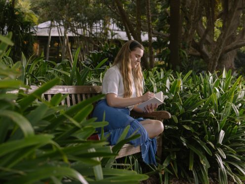 A woman writing sitting on the bench