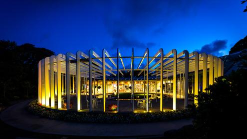 The Calyx architectural building with spokes-like pillars, lit up at night