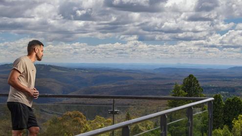 Man on viewing deck gazing at sweeping mountain views at Blue Mountains Botanic Garden