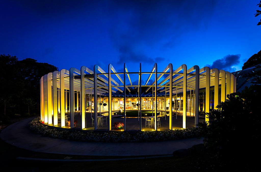 The Calyx architectural building with spokes-like pillars, lit up at night