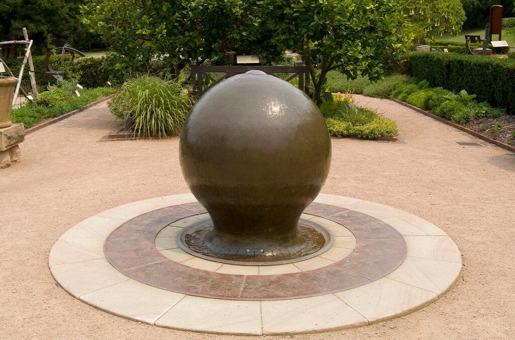 Sculptural fountain with water running gently over the surface of a sphere.