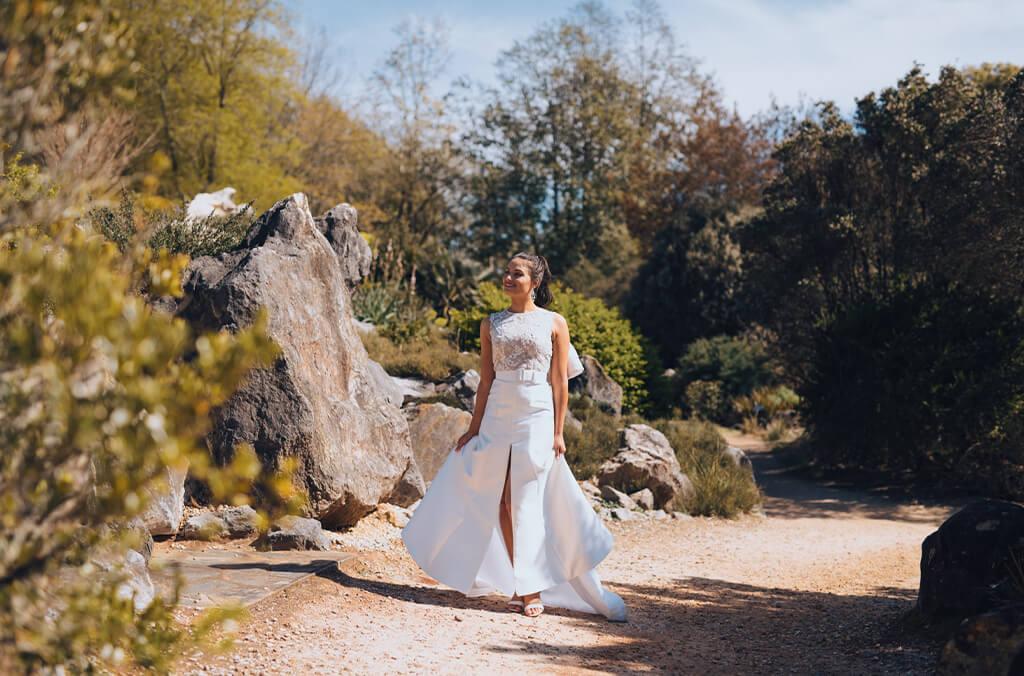 Bride walking along dramatic rock garden landscape with ferns and proteas