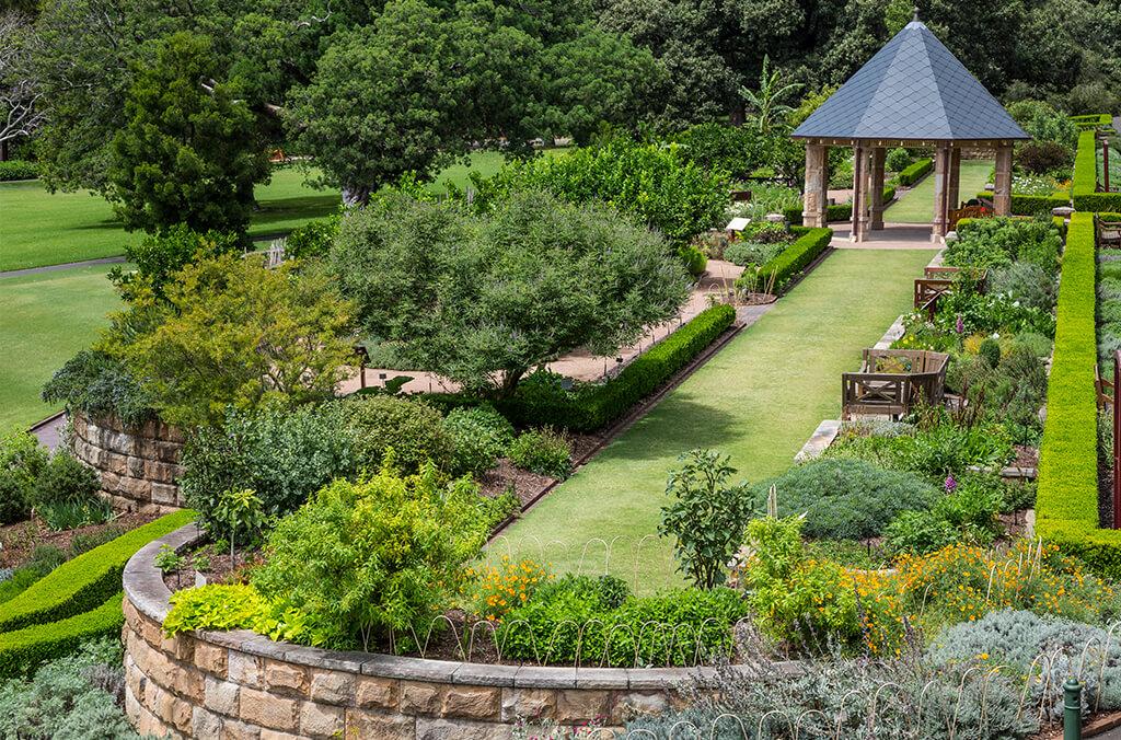 Aerial view of green, manicured garden with lawn and pavilion