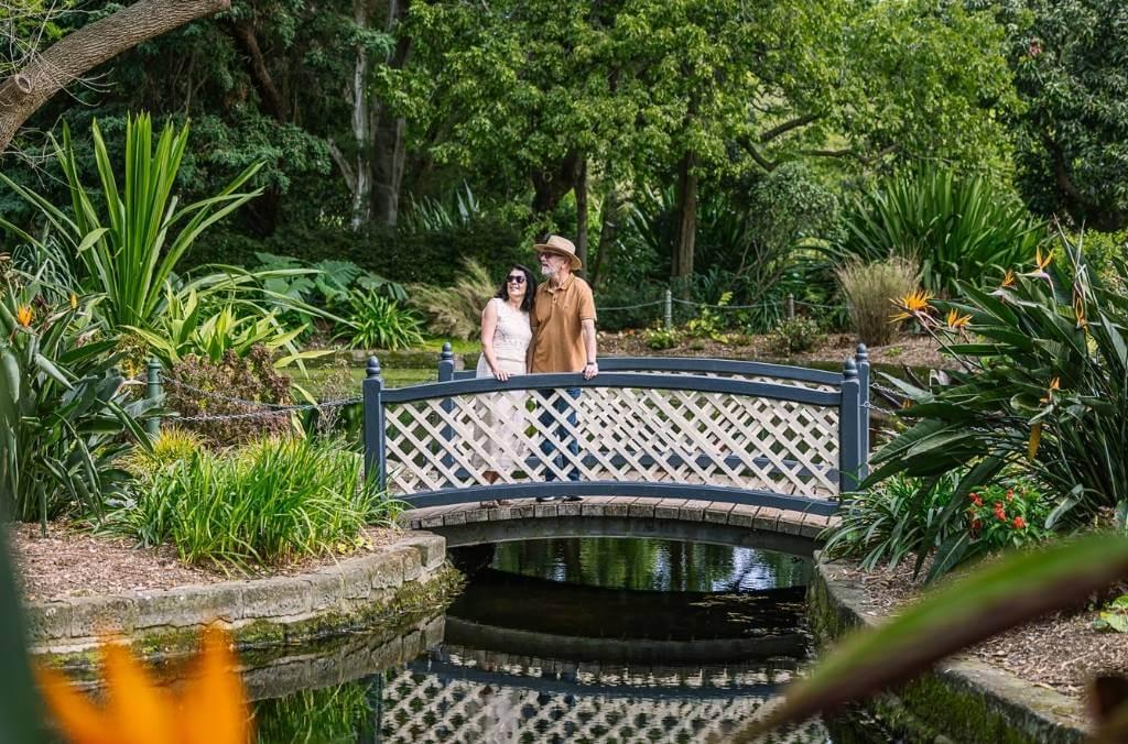 Couple on a bridge over creek in tropical garden