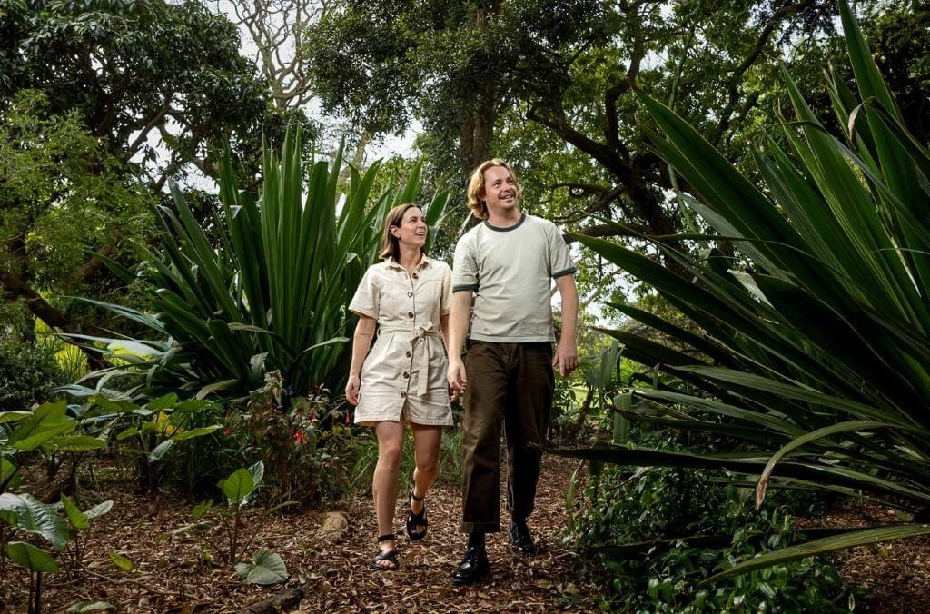 Young couple walking through a shady and lush tropical garden at the Royal Botanic Garden Sydney