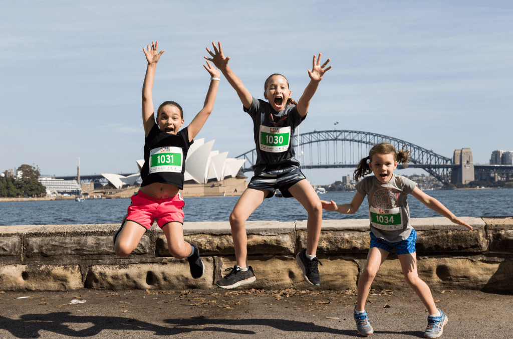 children jumping in front of harbour bridge