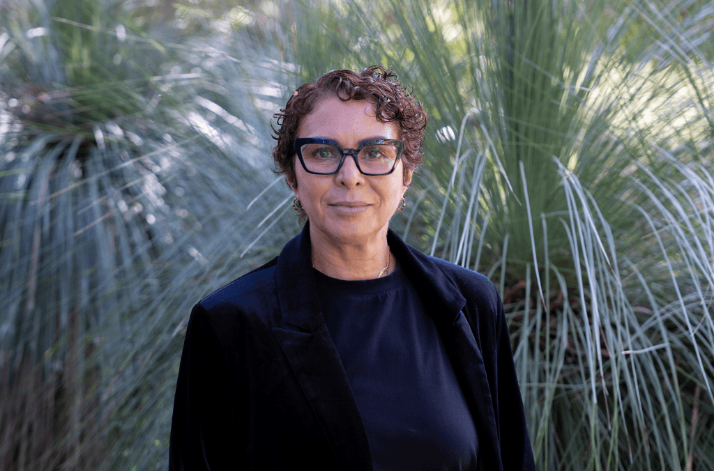 A woman in front of a grass tree