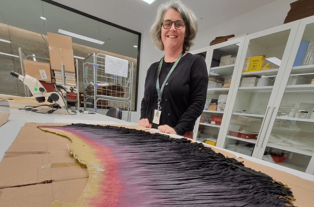 a woman looking down at a plant specimen 